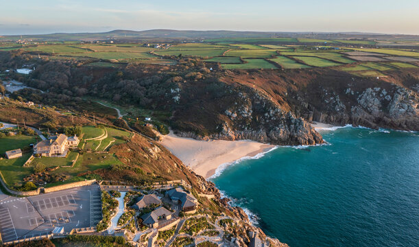 Aerial drone landscape image of Minnack Theatre headland around Porthcurno beach in Cornwall England at dawn
