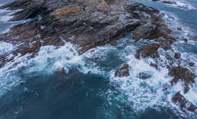 Beautiful aerial drone landscape image of Prussia Cove at sunrise in Cornwall England with atmospheric daramatic sky and clouds