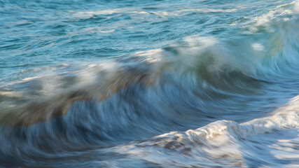 Large Powerful jade turquoise colored waves crashing at Sennen Cove in Cornwall during late sunset