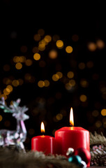 Obraz na płótnie Canvas Two burning red candles on the New Year's table