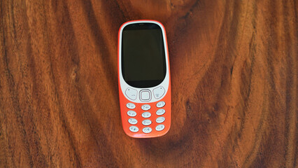 A keypad phone with buttons isolated on black background. Old Cell phone with black display....