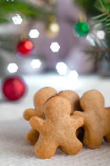 Homemade Christmas gingerbread man cookies close up on a festive background among garland lights. Merry Christmas and happy New Year concept.