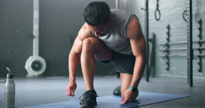 Fitness, exercise and gym man prepare shoes for training, cardio exercise or workout. Footwear, start or healthy athlete ties shoe lace getting ready for exercising for training, health and wellness