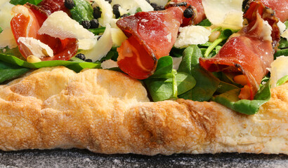Italian pizza with Grana Cheese Rucola cheese flakes and sliced bresaola salami - obrazy, fototapety, plakaty