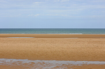 golden beach by the sea and puddles after high tide
