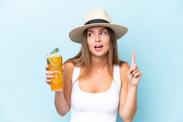 Young beautiful woman holding a cocktail isolated on blue background intending to realizes the solution while lifting a finger up