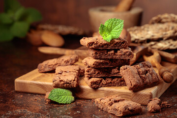 Brownie with mint on an old table with kitchen utensils.