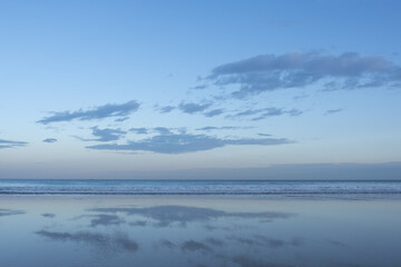 Sky with clouds reflected on beach and sea with copy space, wallpaper use.