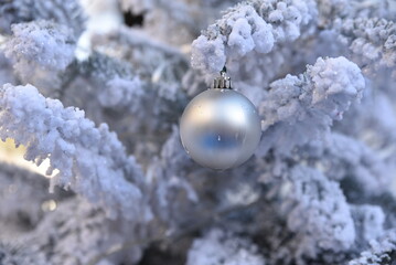 Boule de Noël blanc nacré dans sapin enneigé