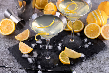 Obraz na płótnie Canvas Lemon drop martini with zest offers a sophisticated twist to a cocktail. This light and savory favorite combines vodka, orange liqueur, fresh lemon juice and zest.