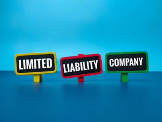 Colored wooden board with the word LIMITED LIABILITY COMPANY on blue background. Business concept.