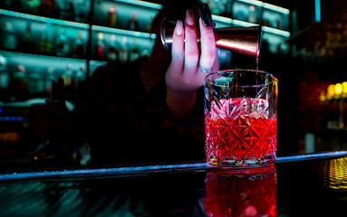 making negroni cocktail. Negroni classic cocktail and gin short drink with sweet vermouth, red bitter liqueur in bar