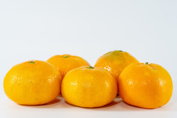Many fresh orange tangerine fruit isolated over white