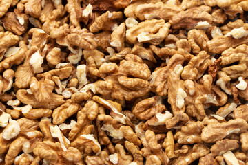 Closeup of big shelled walnuts pile. Nuts are a source of vegetable protein.