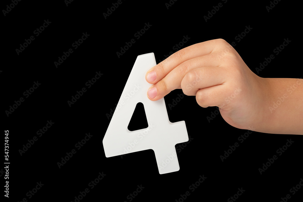 Poster number four in hand isolated on black background. number four in a child's hand, holding on a black 