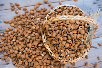 almonds in a basket on a wooden table. Delicious almonds, a variety of Greek origin and late flowering and harvesting retsιοu
