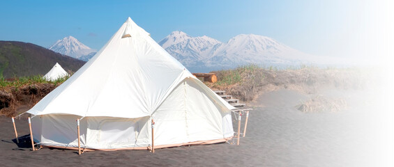 Selective focus. Glamping house in summer and volcano, rural landscape, tent houses in Kamchatka peninsula © bborriss