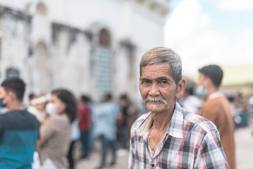 An old asian man outside the church attending a packed sunday morning mass.
