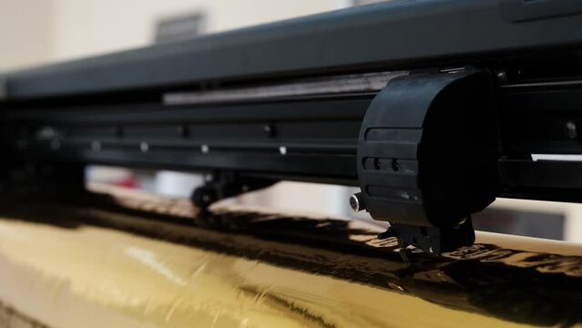 Golden foil cutting plotter machine. Vinyl cutter plotter machine and moving cutting head.	