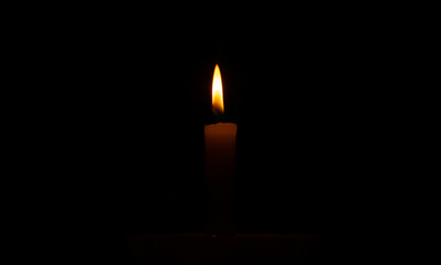 Orange candle in the dark. Orange candle flame in the dark