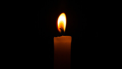 Orange candle in the dark. Orange candle flame in the dark