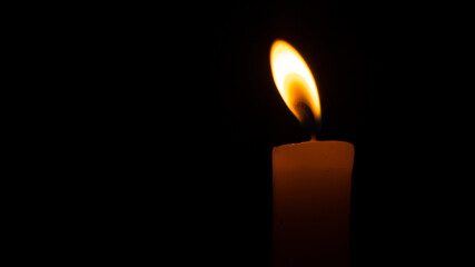 Orange candle in the dark. Orange candle flame in the dark
