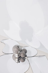 Abstract Christmas card with shiny silver baubles reflecting in small mirrors and their shadows on the wall, Holiday family bonding concept