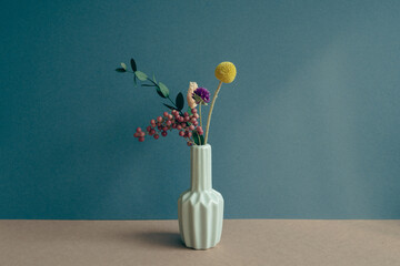 Vase of dry flower on table. navy blue wall background. home interior