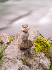 Fototapeta na wymiar Cairn posé sur un rocher au bord d'un torrent de montagne
