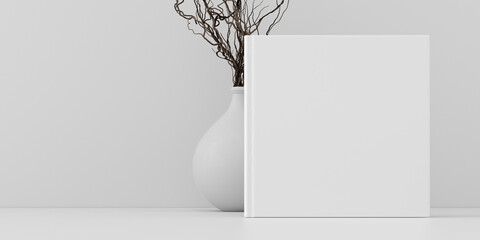 Square book cover mock up standing on a white desk with white wall background.