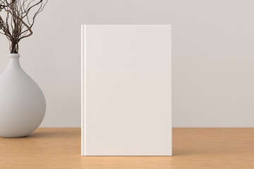 Vertical  book cover mock up standing on a wooden desk with white wall background.