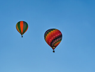 Two colorful hot air balloons flying through the sky.