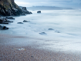 Fototapeta na wymiar Rock sand and stone coast with silk water