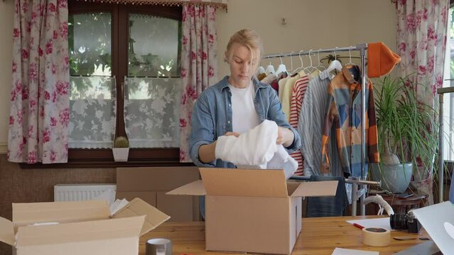 Woman sorting used clothes for resale or donation, second hand clothes concept.