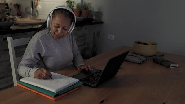 Senior African woman working on a laptop at home - Smart work and technology concept