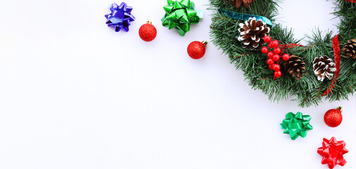 Background for the New Year, Christmas decor on a white background, banner. Christmas wreath with ribbons and cones, Christmas balls and bows