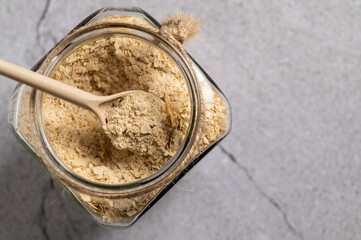 nutritional yeast in flakes, deactivated, not live, B vitamins, in a jar, focus on a spoon, close-up, top view