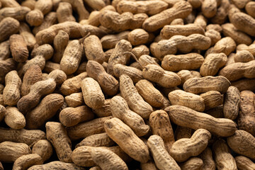 Background of dry unshelled peanuts, macro
