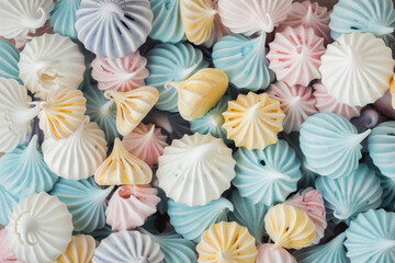 Fototapeta na wymiar Multicolored crispy meringue cookies as a textured background. Close up of twisted meringue. Pastel colors. Background for confectionery menu