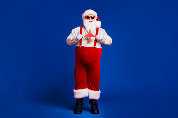 Full length body size view of his he attractive cheerful cheery glad fat Santa holding in hands paper plane figure isolated bright vivid shine vibrant red burgundy maroon color background