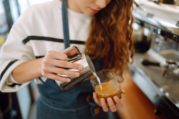 Barista holding cup getting fresh coffee that being brewed by the machine in cafe. Professional coffee brewing.