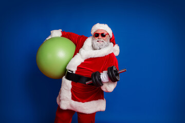 Photo of handsome strong santa claus wear red costume hat dark holding fitball building muscles...