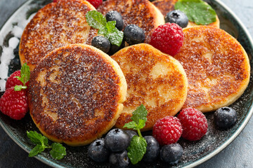Cottage cheese pancakes served with blueberries, raspberries, strawberry jam and mint leaves,...