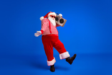 Full length body size view of his he handsome bearded fat overweight cheery Santa listening pop...