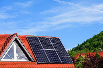 Fototapeta premium Solaranlage auf modernem, rotem Hausdach mit Dreiecksgiebel