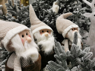 soft toy fabulous gnome stands against the background of an elegant Christmas tree. Good New Year spirit. gnome . Festive christmas decorations.