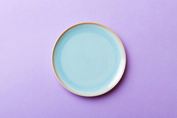 Top view of isolated of colored background empty round blue plate for food. Empty dish with space...