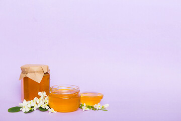 robinia honey bollte with acacia blossoms on colored table
