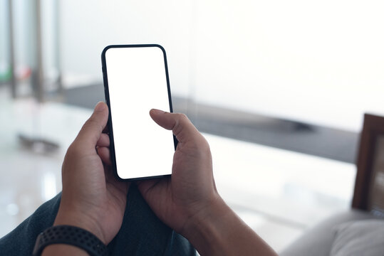 Mobile phone mockup for advertising. Mock up image of man hand holding and using smartphone with blank screen for mobile app design or text advertisement