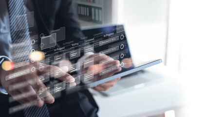 Business developer using Kanban board framework on digital tablet and laptop computer. Agile...
